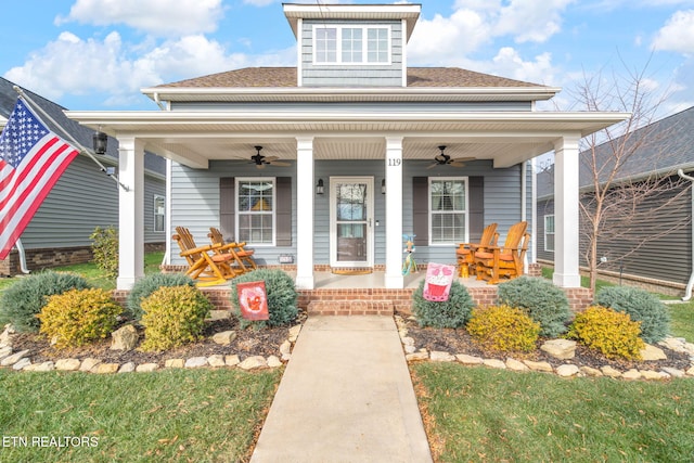 view of front of house with ceiling fan, a front lawn, and covered porch