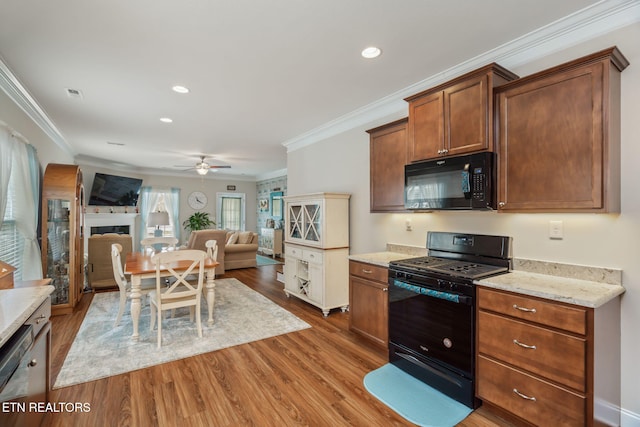 kitchen featuring ceiling fan, crown molding, hardwood / wood-style floors, and black appliances