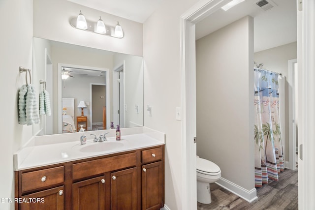 bathroom featuring ceiling fan, hardwood / wood-style floors, toilet, and vanity