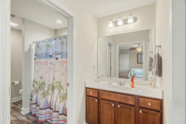 bathroom with ceiling fan, wood-type flooring, toilet, and vanity