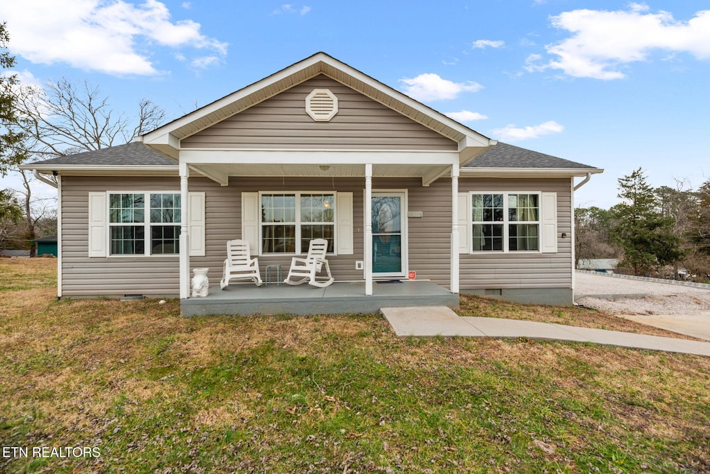 back of property featuring a porch and a yard