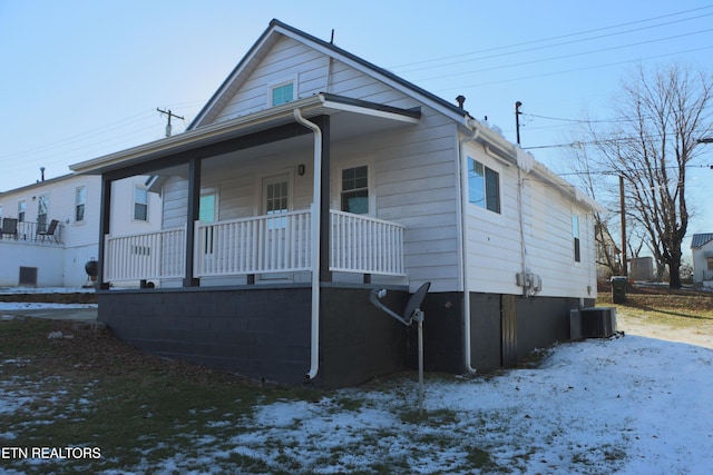 bungalow-style home with a porch and cooling unit