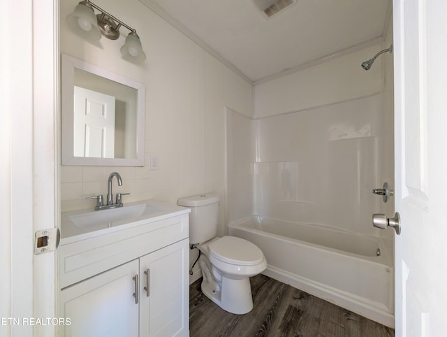 full bathroom featuring toilet, vanity, tasteful backsplash, washtub / shower combination, and wood-type flooring