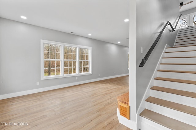 stairway featuring a healthy amount of sunlight and hardwood / wood-style floors