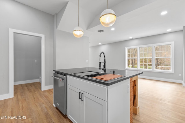 kitchen featuring pendant lighting, sink, stainless steel dishwasher, and an island with sink