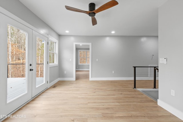 empty room featuring ceiling fan, light hardwood / wood-style floors, and french doors