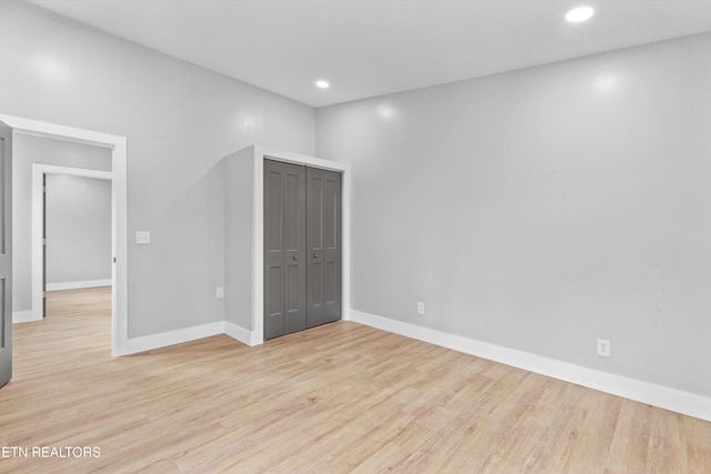 unfurnished bedroom with light hardwood / wood-style flooring and a closet