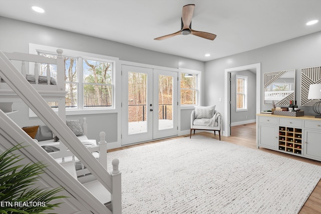 living area featuring french doors, ceiling fan, and light hardwood / wood-style flooring