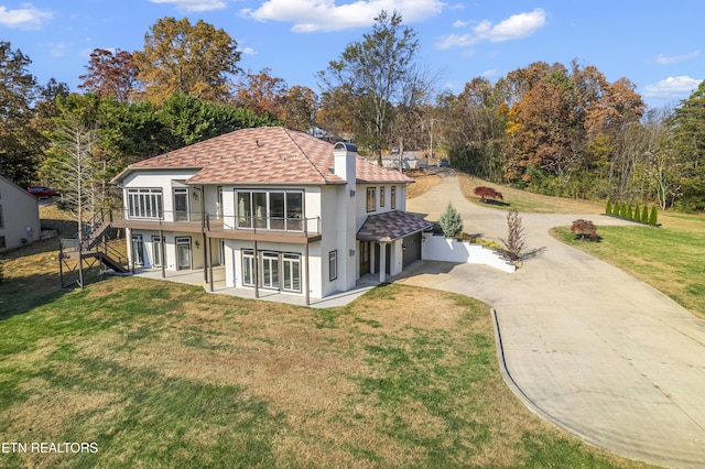 back of property featuring a deck, a patio area, and a lawn