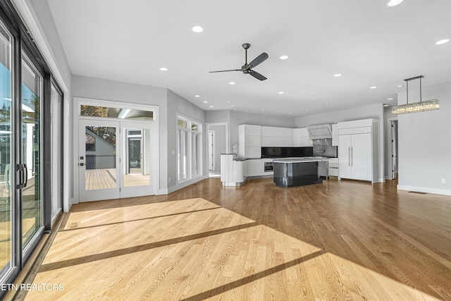 unfurnished living room with ceiling fan and light hardwood / wood-style floors