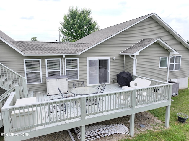 rear view of house with central AC unit and a deck