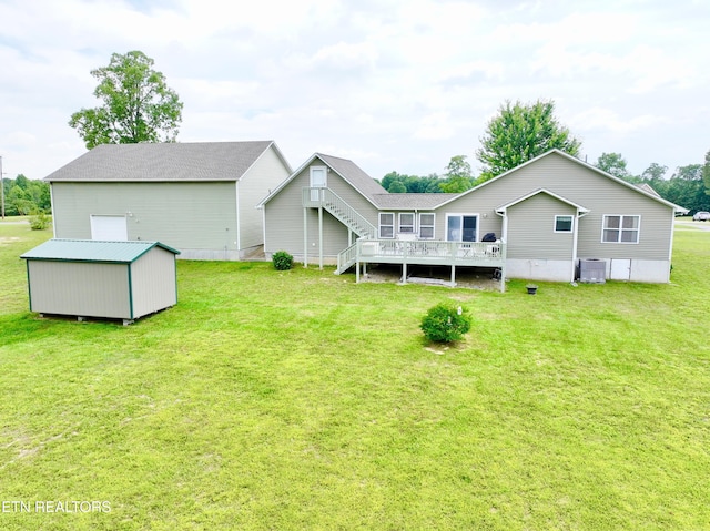 back of house featuring central air condition unit, a wooden deck, a yard, and a shed