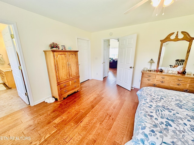 bedroom with light hardwood / wood-style flooring, ensuite bath, and ceiling fan