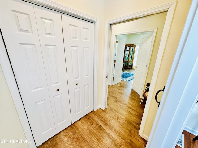 corridor with light hardwood / wood-style flooring