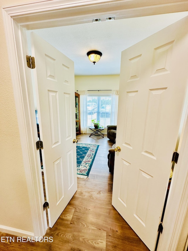 corridor with light hardwood / wood-style floors