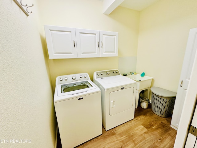 laundry area with cabinets, light wood-type flooring, and independent washer and dryer