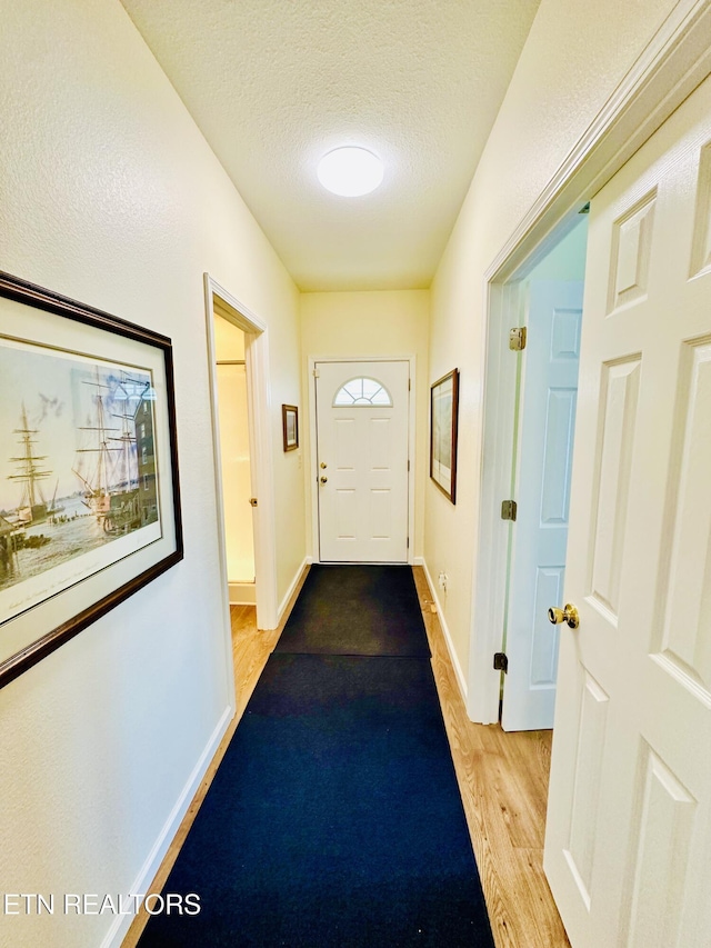 entryway featuring light hardwood / wood-style flooring and a textured ceiling