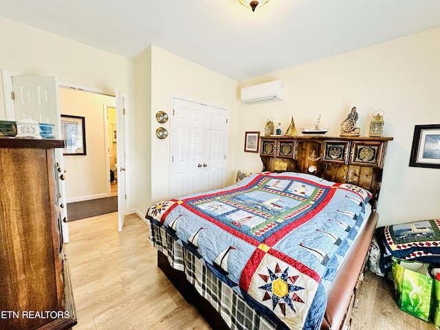 bedroom featuring hardwood / wood-style floors, a closet, and a wall mounted AC