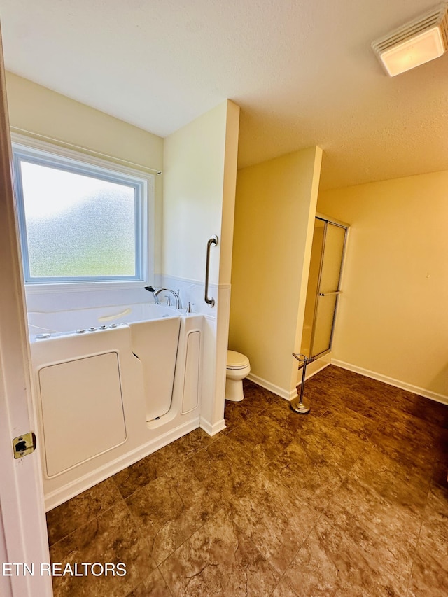 813 Clear Creek Pkwy, Clarkrange, TN 38553 - bathroom with toilet, a garden tub, a shower with door, and baseboards
