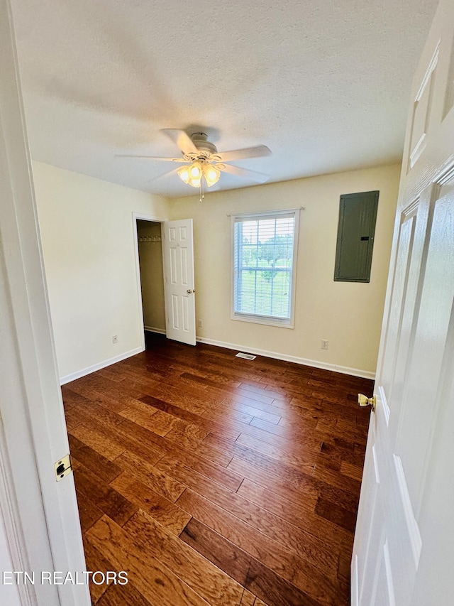813 Clear Creek Pkwy, Clarkrange, TN 38553 - unfurnished room with electric panel, dark wood-style flooring, baseboards, ceiling fan, and a textured ceiling