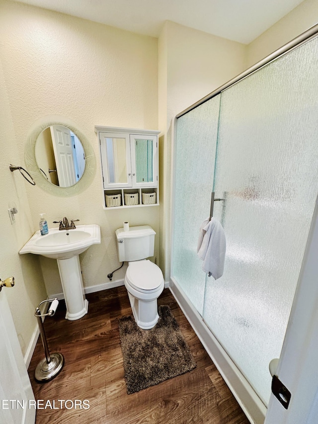 813 Clear Creek Pkwy, Clarkrange, TN 38553 - bathroom featuring a stall shower, wood finished floors, toilet, and baseboards