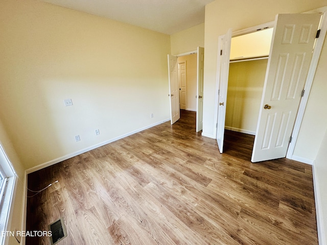 813 Clear Creek Pkwy, Clarkrange, TN 38553 - unfurnished bedroom with wood finished floors, baseboards, a walk in closet, and a closet