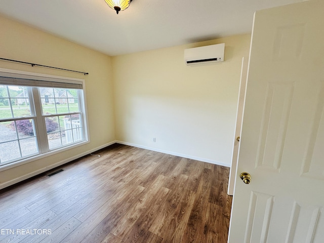 813 Clear Creek Pkwy, Clarkrange, TN 38553 - unfurnished room with a wall unit AC, wood finished floors, and baseboards