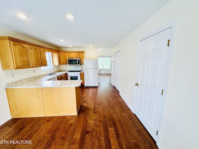 813 Clear Creek Pkwy, Clarkrange, TN 38553 - kitchen with white appliances, a sink, a peninsula, light countertops, and dark wood finished floors