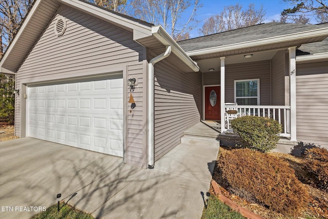 view of exterior entry with covered porch and a garage