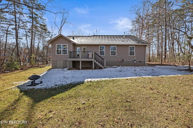 rear view of house featuring a wooden deck and a yard