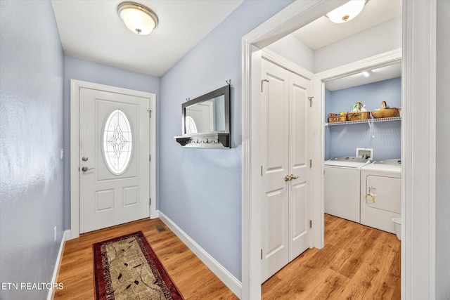 foyer with light hardwood / wood-style floors and washer and clothes dryer