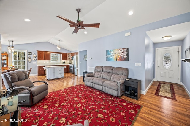 living room featuring vaulted ceiling, ceiling fan, and wood-type flooring