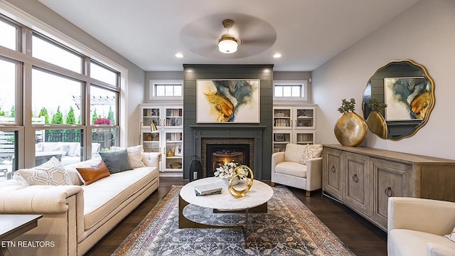 sitting room with dark wood-type flooring and a large fireplace