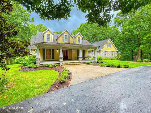 105 Charity Ln, Jamestown, TN 38556 - view of front of house with stone siding, driveway, a porch, and a front lawn