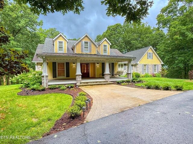 105 Charity Ln, Jamestown, TN 38556 - cape cod home featuring stone siding, a front lawn, covered porch, and decorative driveway