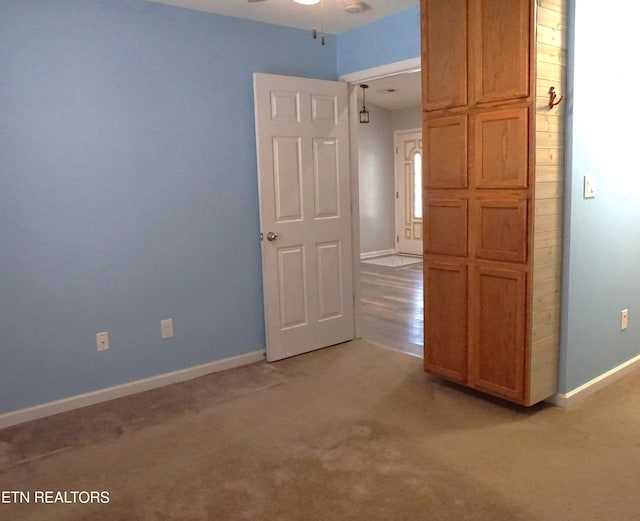 unfurnished room featuring light carpet and ceiling fan