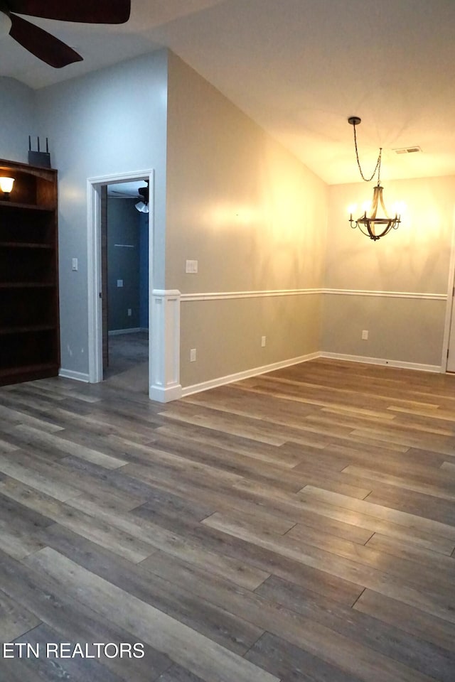 interior space featuring dark wood-type flooring and ceiling fan with notable chandelier