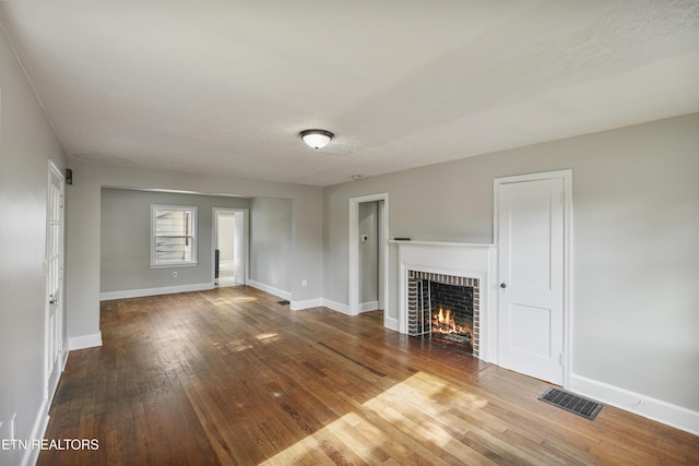 unfurnished living room featuring a fireplace, a textured ceiling, and hardwood / wood-style flooring