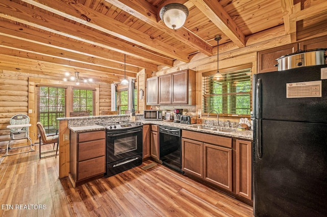 kitchen featuring rustic walls, sink, kitchen peninsula, pendant lighting, and black appliances