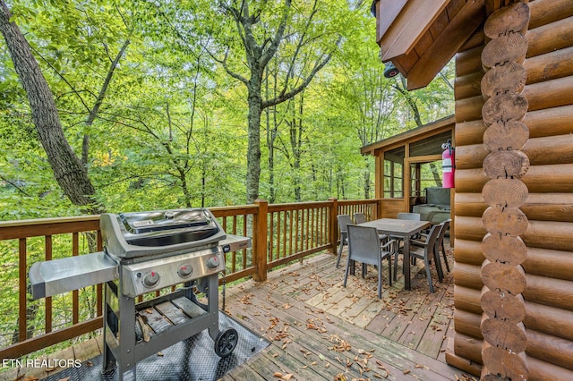 wooden deck featuring area for grilling and a sunroom