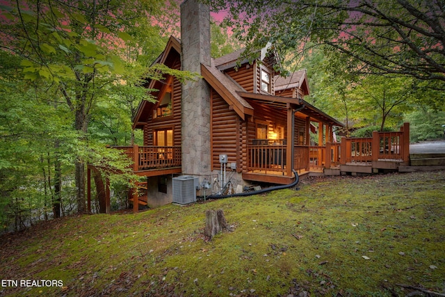 view of property exterior featuring a wooden deck, a yard, and cooling unit