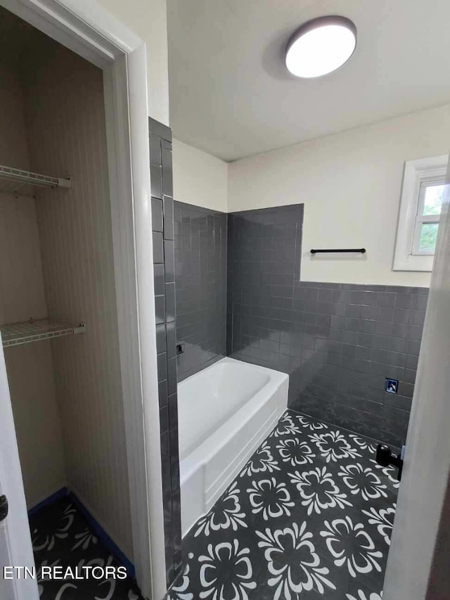 bathroom featuring tile patterned flooring, tile walls, and shower with separate bathtub