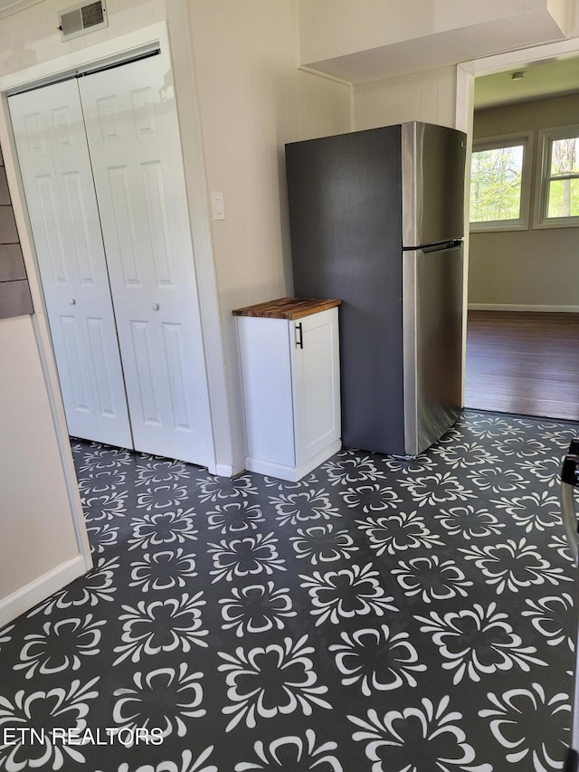 kitchen with wooden counters and stainless steel fridge