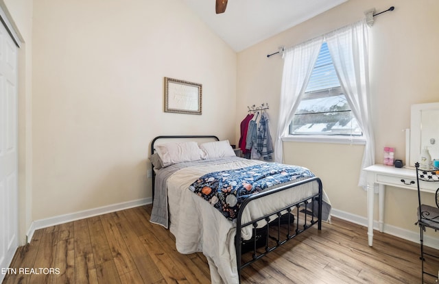 bedroom with ceiling fan, light hardwood / wood-style flooring, and lofted ceiling