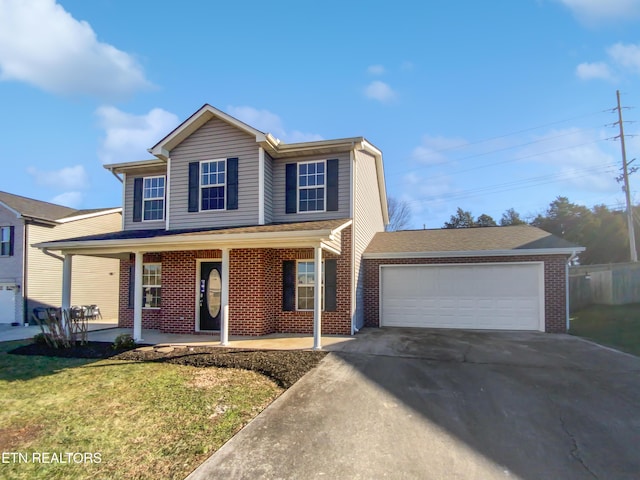 view of front property with covered porch, a front yard, and a garage