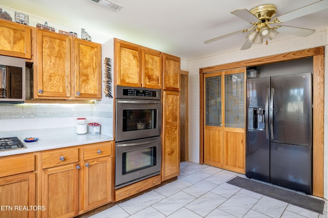 kitchen featuring appliances with stainless steel finishes, tasteful backsplash, light tile patterned floors, and ceiling fan