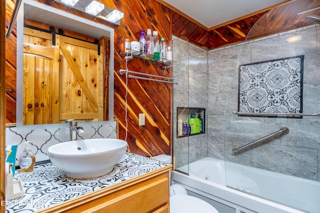 full bathroom with wooden walls, tiled shower / bath combo, toilet, and vanity