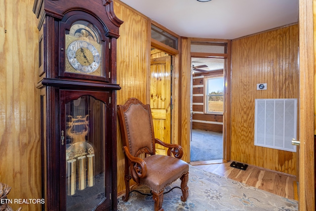 sitting room featuring wooden walls and hardwood / wood-style floors