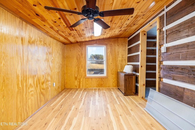 unfurnished room featuring ceiling fan, wood ceiling, wooden walls, and light hardwood / wood-style flooring