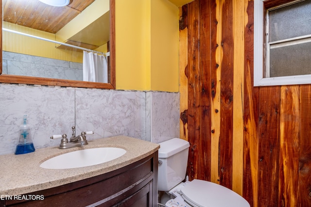 bathroom with vanity, toilet, and backsplash